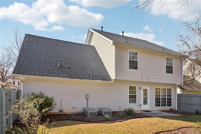 back of house with a yard, a shingled roof, cooling unit, and fence