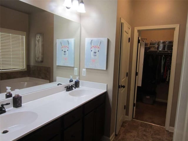 bathroom with a sink, a walk in closet, a bath, and double vanity