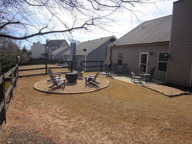 view of yard with a patio area, fence, and a fire pit