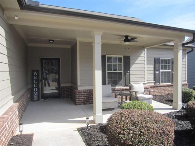 entrance to property featuring brick siding, a porch, and ceiling fan