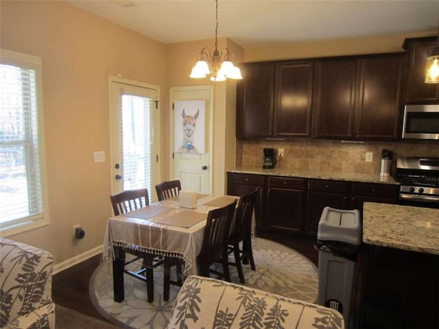 dining room with a notable chandelier, a healthy amount of sunlight, and baseboards