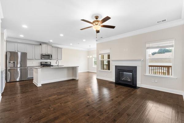 1494 Weeping Tree Cir, Auburn, GA 30548 - unfurnished living room featuring ceiling fan, crown molding, recessed lighting, a fireplace with flush hearth, and dark wood finished floors