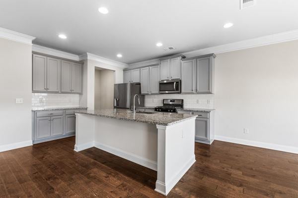 1494 Weeping Tree Cir, Auburn, GA 30548 - kitchen with stainless steel appliances, gray cabinets, backsplash, a center island with sink, and crown molding