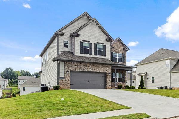 1494 Weeping Tree Cir, Auburn, GA 30548 - craftsman-style home with concrete driveway, brick siding, an attached garage, and a front yard