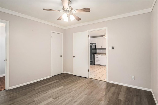725 Bearmeat Spur, Hiawassee, GA 30546 - unfurnished bedroom featuring crown molding, ceiling fan, freestanding refrigerator, baseboards, and wood finished floors