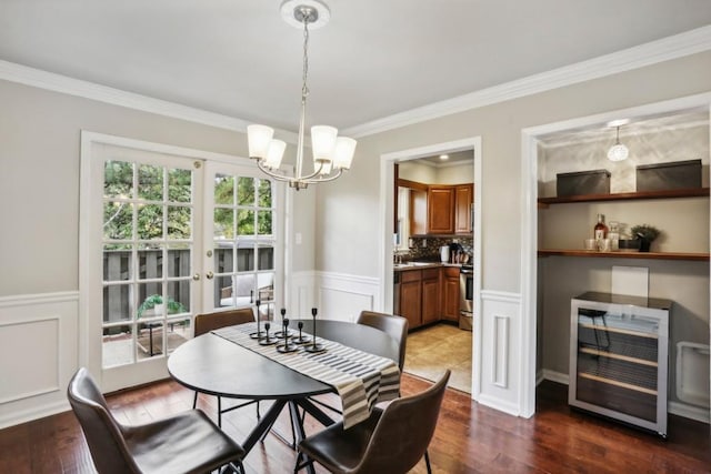 dining room featuring dark hardwood / wood-style flooring, beverage cooler, ornamental molding, and a notable chandelier