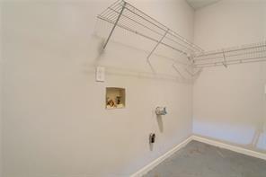 washroom with laundry area, hookup for a washing machine, and baseboards