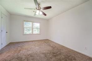 empty room featuring carpet floors and a ceiling fan