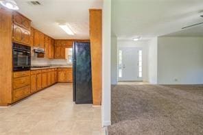 kitchen with black appliances, visible vents, and brown cabinetry