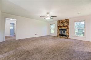 unfurnished living room featuring carpet, ceiling fan, and a fireplace