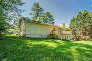 rear view of house with a lawn and a deck