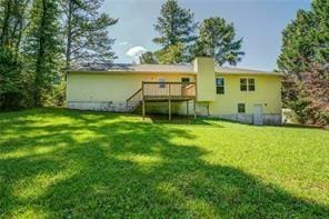 rear view of property with a lawn and a wooden deck