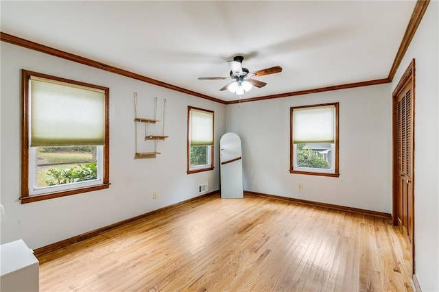 unfurnished bedroom with multiple windows, crown molding, visible vents, and light wood finished floors