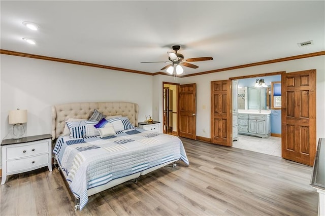 bedroom with crown molding, visible vents, ensuite bathroom, light wood-type flooring, and baseboards