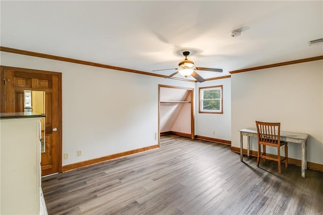 unfurnished room featuring baseboards, crown molding, and wood finished floors