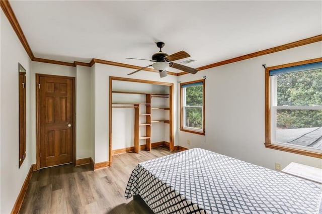 bedroom featuring a closet, multiple windows, visible vents, and wood finished floors