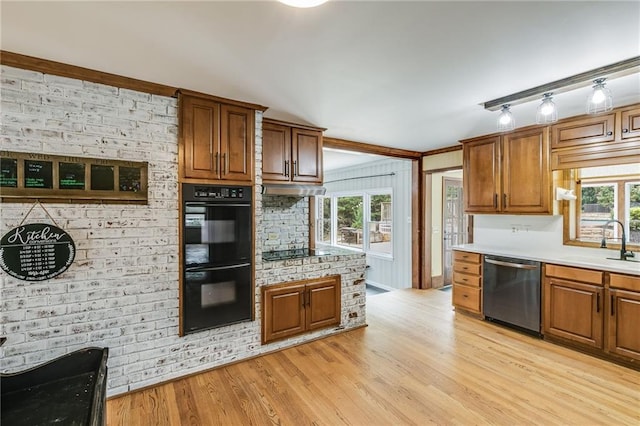 kitchen featuring black appliances, a healthy amount of sunlight, a sink, and light wood-style floors