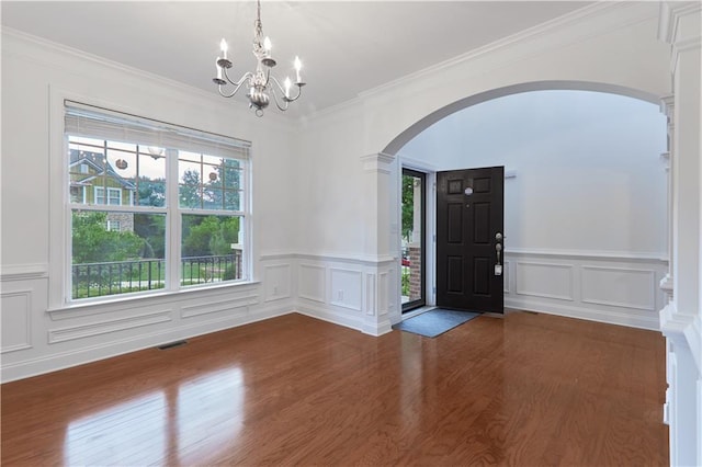 foyer entrance featuring ornamental molding, dark hardwood / wood-style floors, and a notable chandelier