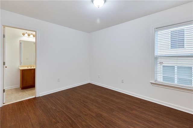 unfurnished bedroom with hardwood / wood-style flooring and ensuite bath