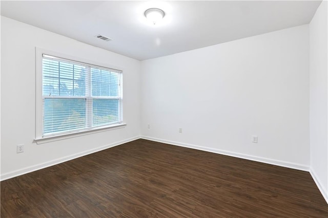 unfurnished room with dark wood-type flooring