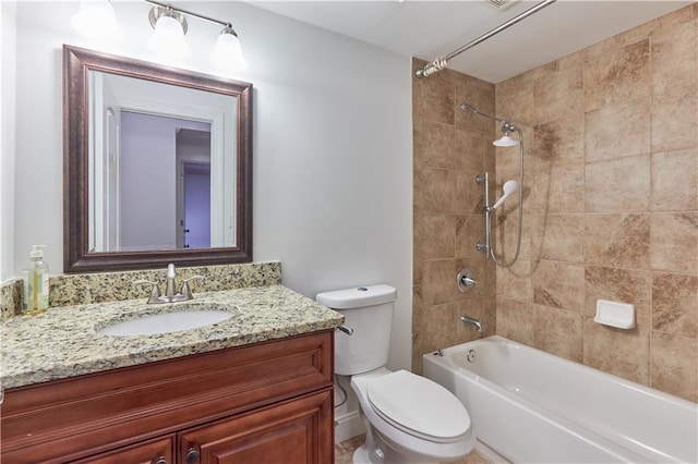 full bathroom featuring vanity, tiled shower / bath, and toilet