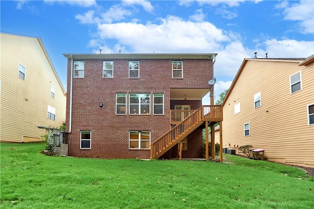 back of property with a lawn, a wooden deck, and central AC