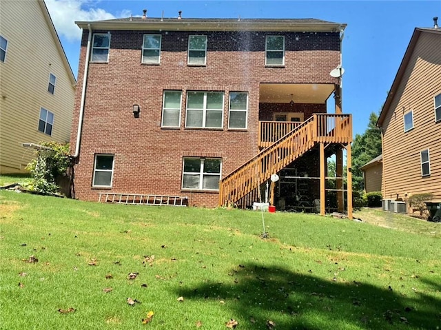 rear view of house featuring central AC unit, a yard, and a wooden deck