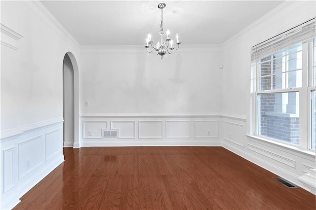 unfurnished dining area featuring dark hardwood / wood-style flooring, ornamental molding, and an inviting chandelier