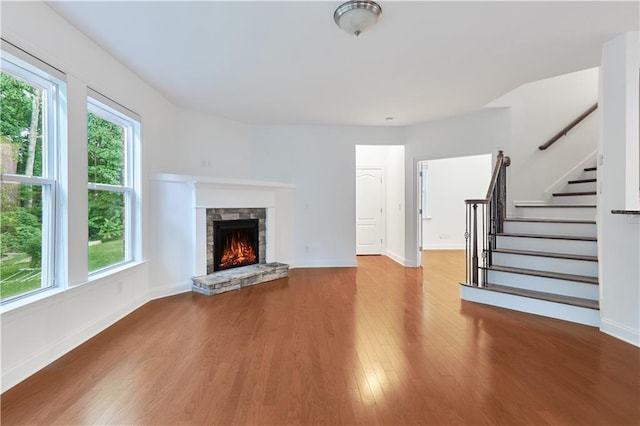 unfurnished living room featuring a fireplace, hardwood / wood-style floors, and plenty of natural light