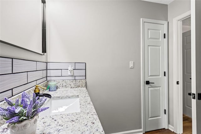 bathroom with wood finished floors, baseboards, and vanity