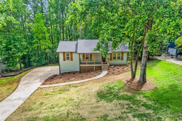ranch-style house featuring a porch, driveway, and a front lawn