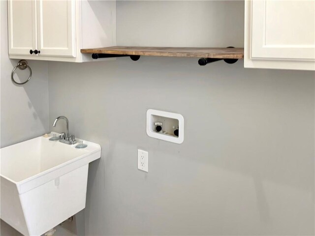 washroom with cabinets, sink, and washer hookup