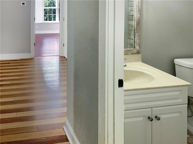 bathroom with vanity, toilet, and hardwood / wood-style flooring