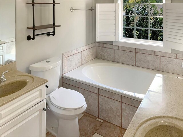 bathroom with tile patterned flooring, tiled bath, toilet, and vanity