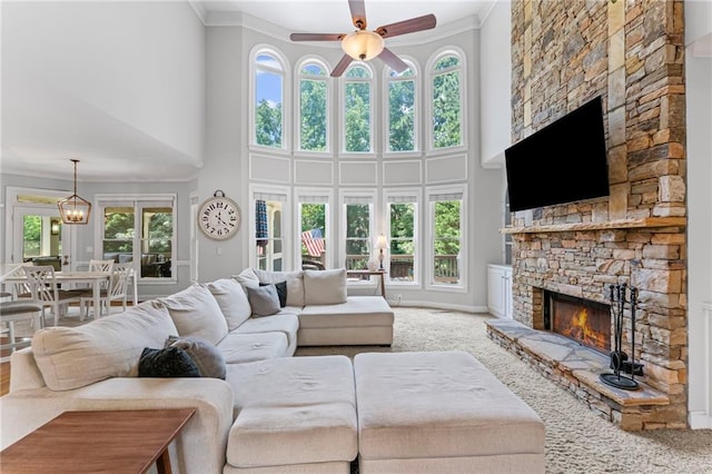 3560 Greenside Ct, Dacula, GA 30019 - carpeted living area with crown molding, a fireplace, a ceiling fan, and a towering ceiling