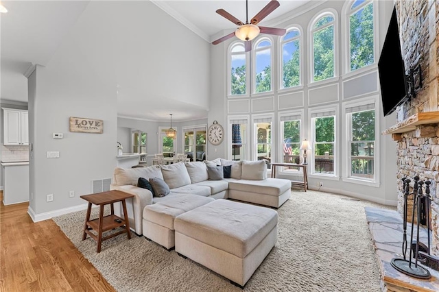 3560 Greenside Ct, Dacula, GA 30019 - living area with high vaulted ceiling, ceiling fan, a fireplace, light wood-style floors, and crown molding