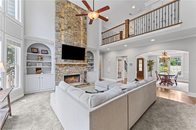 3560 Greenside Ct, Dacula, GA 30019 - living area featuring a towering ceiling, a fireplace, a chandelier, arched walkways, and ceiling fan