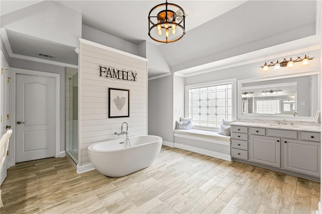 3560 Greenside Ct, Dacula, GA 30019 - full bathroom featuring a freestanding bath, a chandelier, vanity, a shower stall, and vaulted ceiling