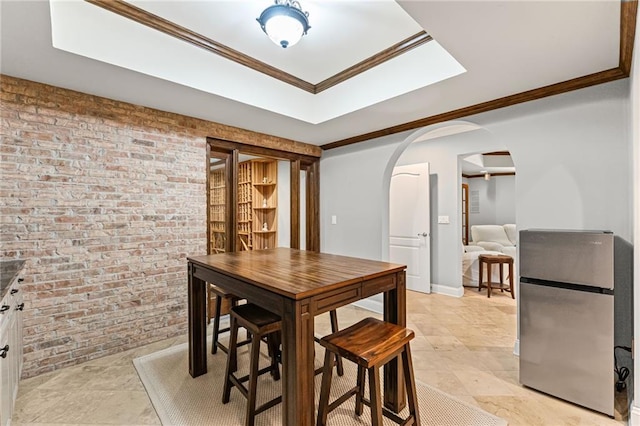 3560 Greenside Ct, Dacula, GA 30019 - dining area with arched walkways, brick wall, ornamental molding, and a tray ceiling