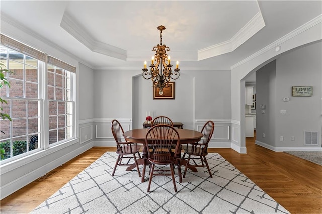 3560 Greenside Ct, Dacula, GA 30019 - dining space with arched walkways, healthy amount of natural light, wood finished floors, ornamental molding, and a wainscoted wall
