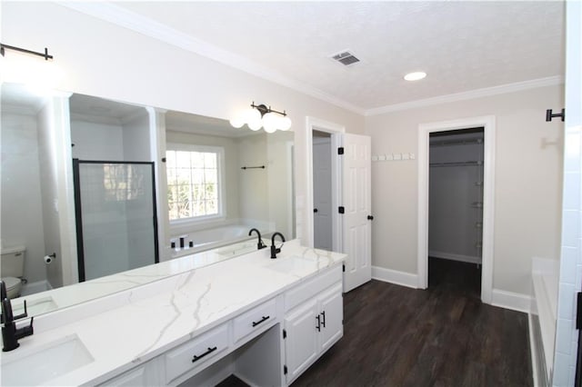 full bathroom featuring toilet, crown molding, vanity, hardwood / wood-style flooring, and plus walk in shower