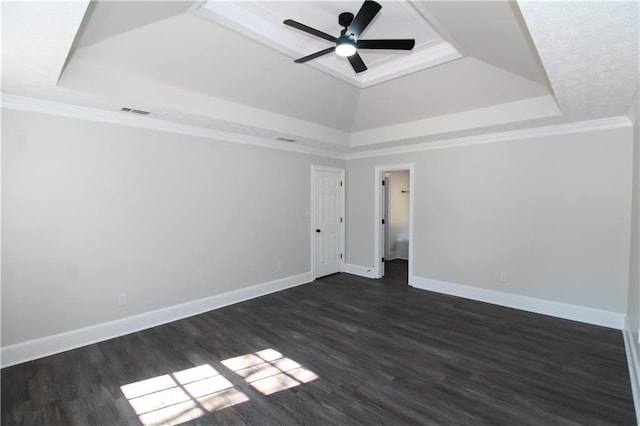 unfurnished room with crown molding, dark wood-type flooring, and a raised ceiling