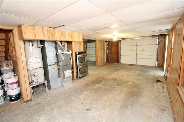 garage with gas water heater and wood walls