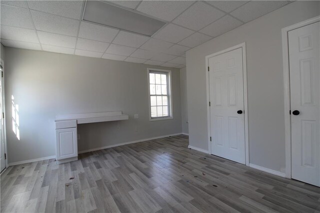 spare room featuring light hardwood / wood-style floors and a drop ceiling