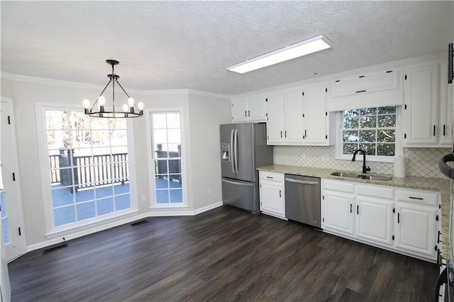 kitchen featuring dark hardwood / wood-style floors, decorative light fixtures, sink, white cabinets, and stainless steel appliances