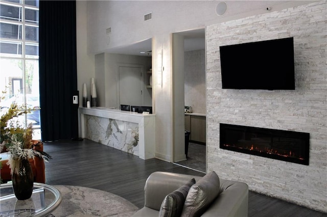 711 Cosmopolitan Dr Unit 413, Atlanta, GA 30324 - living area featuring a stone fireplace, wood finished floors, and a towering ceiling