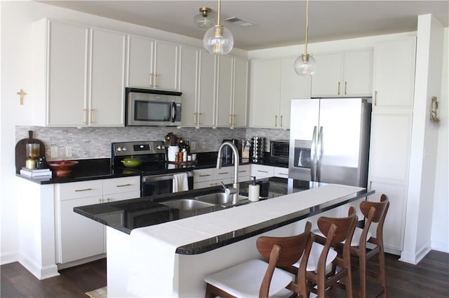 711 Cosmopolitan Dr Unit 413, Atlanta, GA 30324 - kitchen with appliances with stainless steel finishes, tasteful backsplash, dark wood-style flooring, and a breakfast bar