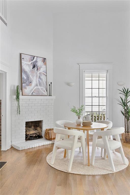 343 Josephine St NE, Atlanta, GA 30307 - dining area featuring a brick fireplace, a towering ceiling, and wood finished floors