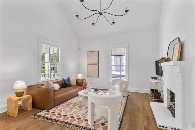 343 Josephine St NE, Atlanta, GA 30307 - living room with wood finished floors, a chandelier, high vaulted ceiling, and a fireplace