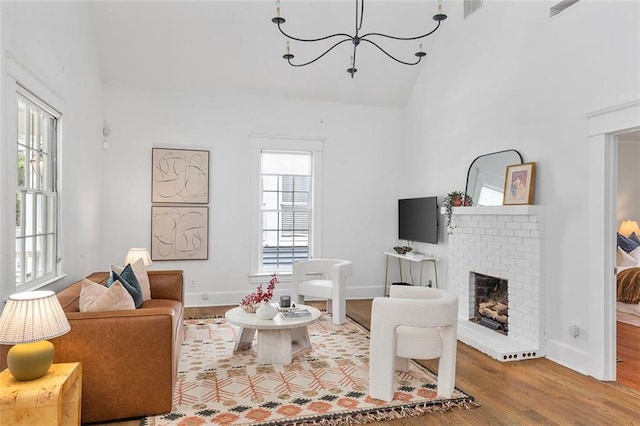 343 Josephine St NE, Atlanta, GA 30307 - living area featuring wood finished floors, high vaulted ceiling, a chandelier, and a fireplace